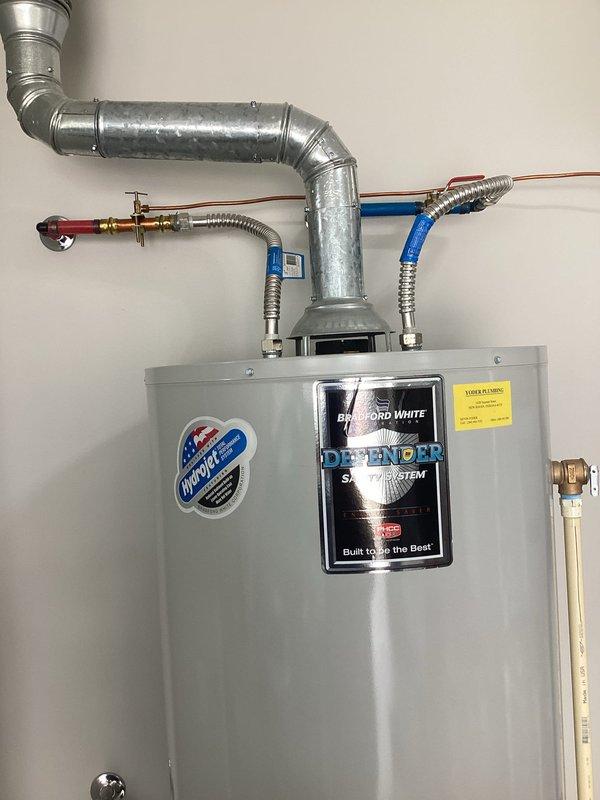Responded to no hot water complaint at residential property. Upon arrival, contacted customer as requested prior to beginning work. Inspected Bradford White Defender tanked water heater and diagnosed system failure. Performed complete water heater replacement, installing new Bradford White Defender model unit. Connected all supply and discharge plumbing lines including copper hot and cold water pipes with proper shutoff valves and flexible connectors. Installed galvanized metal exhaust ductwork with curved elbow joints for proper ventilation routing. Connected yellow flexible gas line to unit with appropriate shutoff valve at gas control box. Tested all connections for leaks, verified proper venting, and confirmed hot water restoration throughout residence. System operational upon departure.