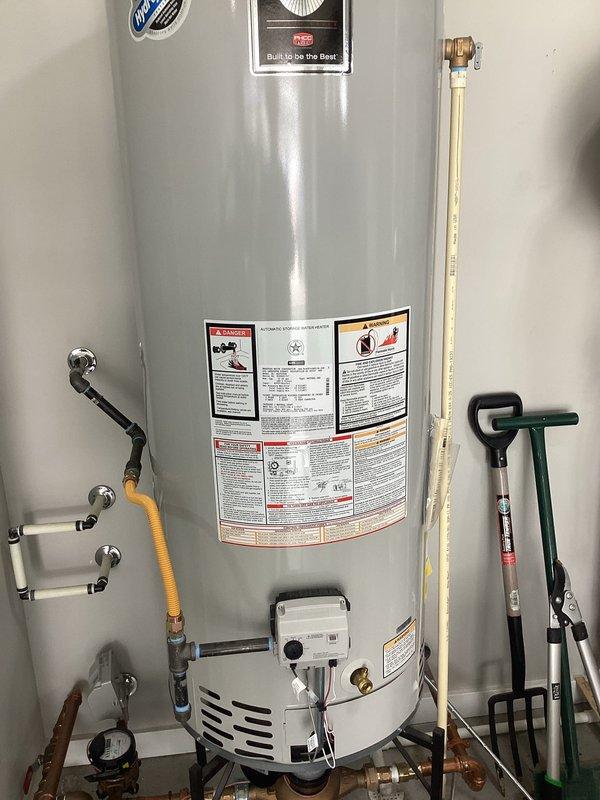 Responded to no hot water complaint at residential property. Upon arrival, contacted customer as requested prior to beginning work. Inspected Bradford White Defender tanked water heater and diagnosed system failure. Performed complete water heater replacement, installing new Bradford White Defender model unit. Connected all supply and discharge plumbing lines including copper hot and cold water pipes with proper shutoff valves and flexible connectors. Installed galvanized metal exhaust ductwork with curved elbow joints for proper ventilation routing. Connected yellow flexible gas line to unit with appropriate shutoff valve at gas control box. Tested all connections for leaks, verified proper venting, and confirmed hot water restoration throughout residence. System operational upon departure.
