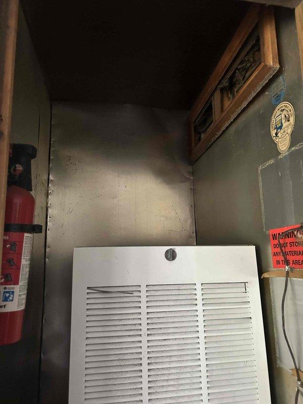 Responded to no-cooling complaint on all-electric residential property. Upon arrival, assessed existing cylindrical air conditioning condenser unit with gray metal exterior located on gravel pad adjacent to building foundation. Evaluated electrical disconnect, refrigerant line routing, and conduit connections. Inspected indoor mechanical space with louvered ventilation panels and noted environmental conditions within enclosed utility area. Presented heat pump replacement options to address failed cooling system, discussed financing alternatives, and provided comprehensive estimate for complete HVAC system replacement suitable for all-electric home configuration.