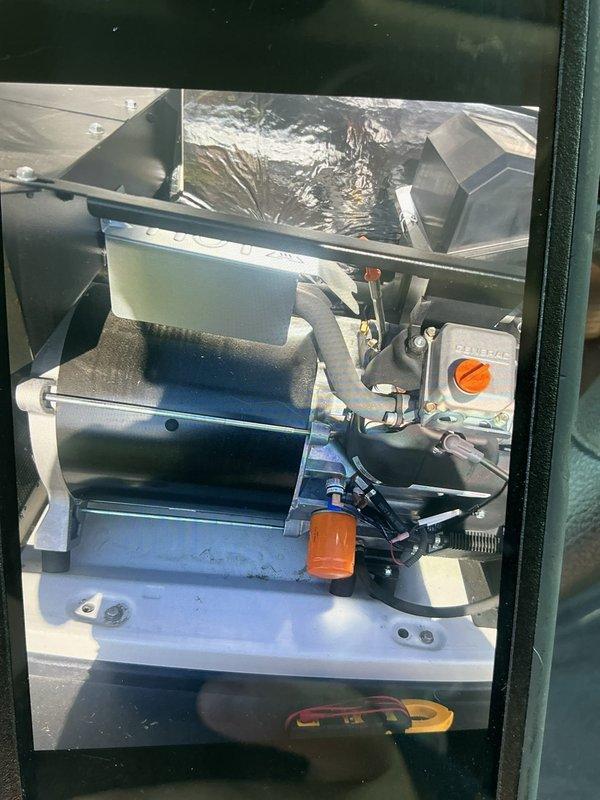 Performed scheduled maintenance on Generac 22kW standby generator. Inspected internal compartment components, electrical connections, and control systems. Replaced air filters with new pleated media elements. Verified proper operation of all mechanical and electrical components, including blower assembly and control box with indicator dial. Documented system condition with photographs showing clean internal compartment, drain pan, and replaced filters.