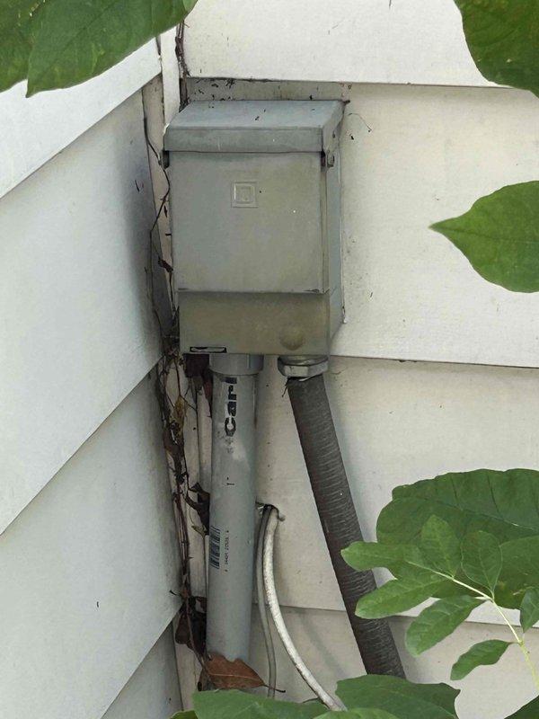 Conducted on-site evaluation for mini split installation in 1200 square foot cottage residence. Assessed existing electrical infrastructure including exterior disconnect box and conduit routing on building exterior, and evaluated interior space configuration featuring wood-paneled walls and ceiling construction to determine optimal equipment placement and refrigerant line routing for ductless heat pump system.