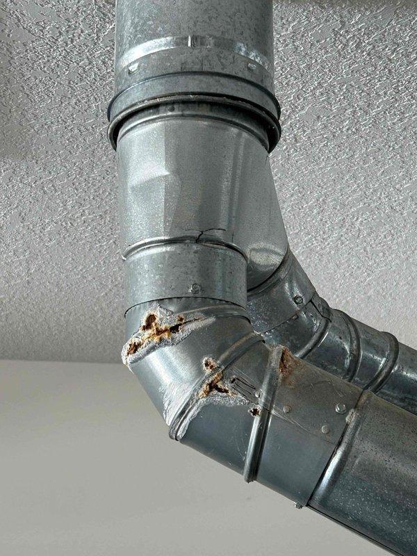 Conducted on-site assessment for air conditioning system replacement. Evaluated existing Trane XB80 furnace and associated ductwork, noting visible corrosion on galvanized metal elbow joint with rust penetration through protective coating. Provided comprehensive replacement estimate with equipment options and installation specifications.