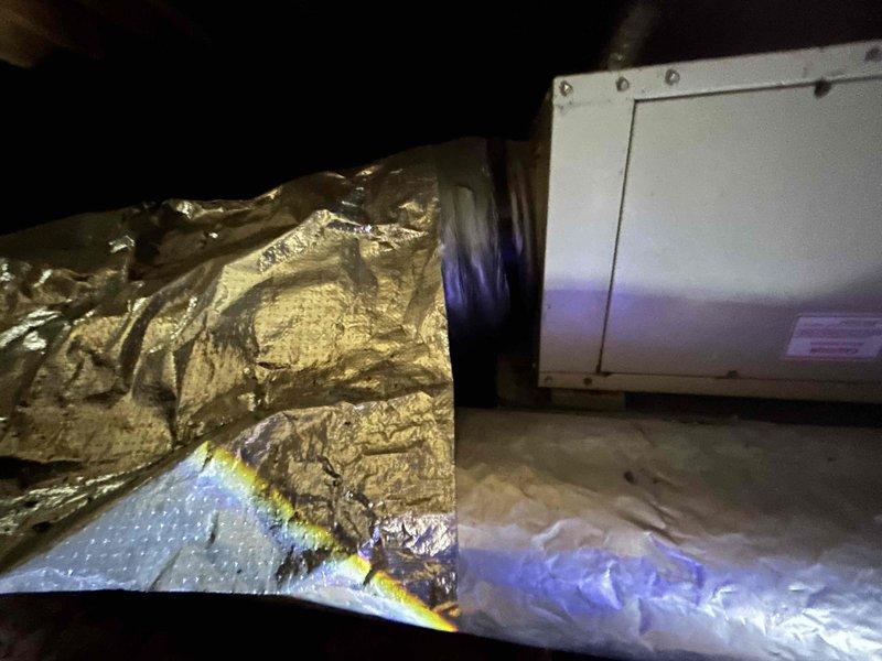 Conducted comprehensive site assessment for Space Pak air conditioning system replacement estimate. Inspected attic-mounted air handler accessed through interior closet and evaluated exterior condensing unit with reported refrigerant leak. Documented existing system configuration including flexible ductwork installation, vapor barrier condition, and outdoor unit placement adjacent to gas meter and electrical service, providing customer with complete replacement options for aging HVAC system.