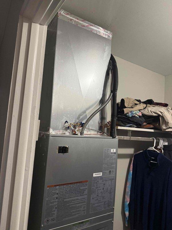 Removed and replaced existing 1.5 ton R22 ceiling fan coil and air conditioning system with new Carrier equipment including FMA5X2400AL 1.5 ton wall-mounted fan coil with 8kW electric strip heat and GA4SAN51800N 1.5 ton 14 SEER single-stage air conditioner utilizing R454 refrigerant. Relocated air handler from ceiling to bedroom closet wall mount configuration. Cut open ceiling and wall sections to access existing ductwork for reconnection to new air handler. Extended refrigerant line set by adding 25 feet of new line to existing run at end of hall, flushed existing line set, and reused for new system. Installed new Honeywell T6 programmable thermostat, PVC equipment pad, electrical disconnect with whip for outdoor unit. Reconnected to existing ductwork in ceiling, condensate drain line, and electrical power supply. Performed system startup, evacuation, and charging procedures to manufacturer specifications. Verified proper airflow, temperature differential, and refrigerant charge. Rem