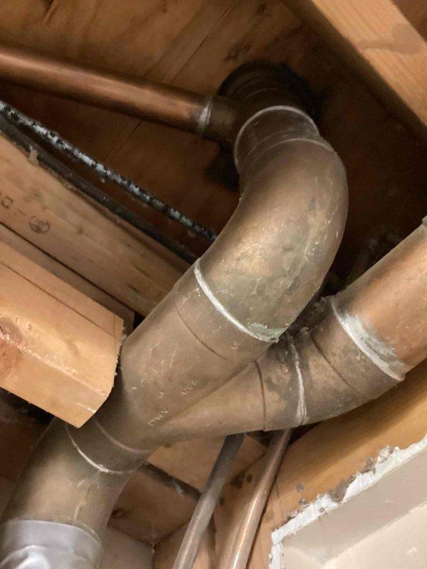 Conducted on-site assessment to provide estimate for complete copper-to-PEX repiping project. Inspected existing copper water supply lines in attic space and under sink areas, documenting current pipe routing, connection points, and fixture supply configurations. Evaluated P-trap drainage assembly and existing shutoff valves showing age-related discoloration and corrosion. Photographed piping layout including runs through ceiling joists and connections at plumbing fixtures to develop comprehensive scope of work for complete copper pipe replacement with PEX tubing system.