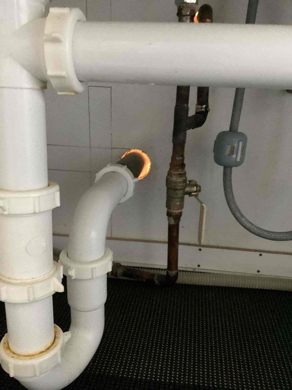 Conducted on-site assessment to provide estimate for complete copper-to-PEX repiping project. Inspected existing copper water supply lines in attic space and under sink areas, documenting current pipe routing, connection points, and fixture supply configurations. Evaluated P-trap drainage assembly and existing shutoff valves showing age-related discoloration and corrosion. Photographed piping layout including runs through ceiling joists and connections at plumbing fixtures to develop comprehensive scope of work for complete copper pipe replacement with PEX tubing system.