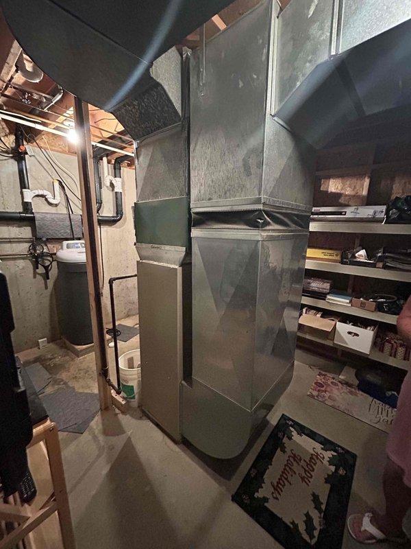Conducted comprehensive assessment of existing HVAC system for complete replacement estimate. Evaluated basement-installed furnace with aged sheet metal ductwork and flex duct connections, along with exterior air conditioning unit featuring refrigerant line connections and electrical disconnect. Documented current equipment conditions, ductwork configuration, and installation parameters to provide accurate replacement specifications for both heating and cooling systems.