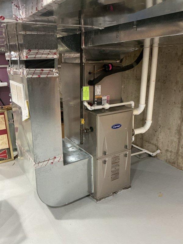 Responded to no cooling complaint and performed system evaluation. Assessed existing Carrier furnace and air conditioning condenser unit for replacement estimate. Documented current basement HVAC installation including furnace, ductwork, plenum, and PVC condensate drainage system. Inspected outdoor condenser unit positioned on concrete pad with electrical disconnect and refrigerant lines. Provided comprehensive estimate options for air conditioning replacement and potential furnace upgrade to restore cooling capability and improve system efficiency.