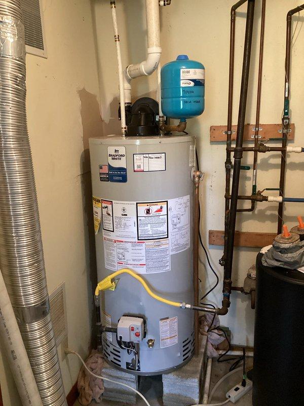 Responded to service call for leaking gas-fired power vent water heater located in walkout basement. Assessed existing unit with blue expansion tank, yellow flexible gas line, white PVC venting, and standard copper plumbing connections. Provided estimate for replacement of failed water heater with new gas power vent unit, including necessary materials and labor for proper installation per code requirements.