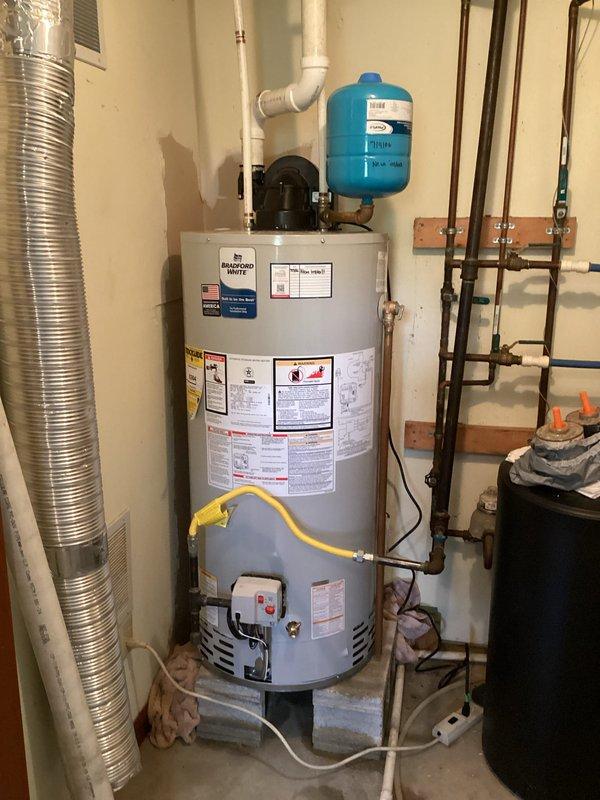 Responded to service call for leaking gas-fired power vent water heater located in walkout basement. Assessed existing unit with blue expansion tank, yellow flexible gas line, white PVC venting, and standard copper plumbing connections. Provided estimate for replacement of failed water heater with new gas power vent unit, including necessary materials and labor for proper installation per code requirements.