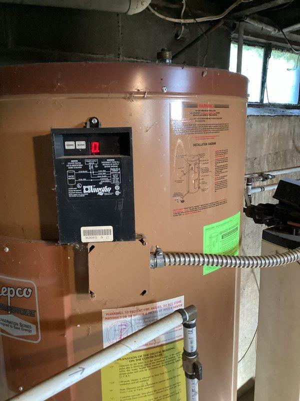 Conducted estimate for water heater replacement in basement location. Evaluated existing electric rental unit from AEP for potential replacement with standard tank-type water heater. Assessed conversion options from electric to gas-fired unit, confirmed natural gas availability at installation site. Documented existing water softener system and basement utility configuration including sump pump installation. Photographed current equipment setup and provided customer with replacement options for both electric and gas water heater models.