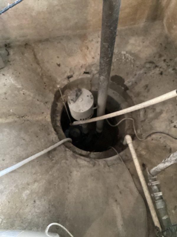 Conducted estimate for water heater replacement in basement location. Evaluated existing electric rental unit from AEP for potential replacement with standard tank-type water heater. Assessed conversion options from electric to gas-fired unit, confirmed natural gas availability at installation site. Documented existing water softener system and basement utility configuration including sump pump installation. Photographed current equipment setup and provided customer with replacement options for both electric and gas water heater models.