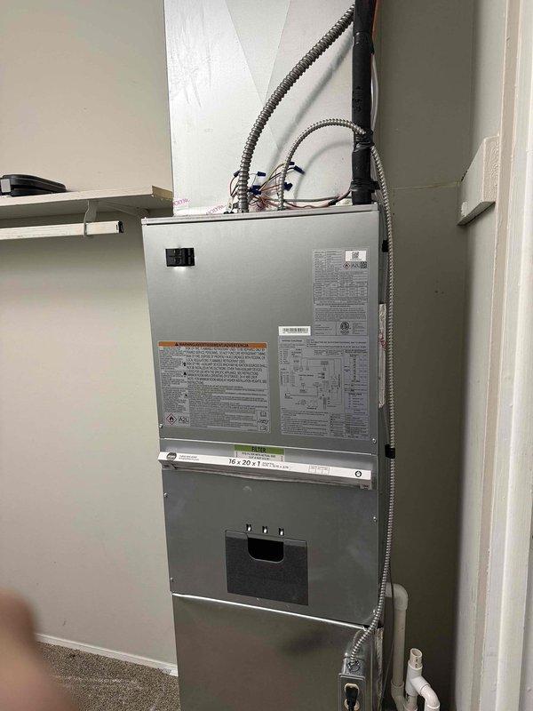 Removed and replaced existing 1.5 ton R22 ceiling-mounted fan coil and air conditioning system with new Carrier equipment in bedroom closet location. Installed Carrier FMA5X2400AL 1.5 ton wall-mounted fan coil with 8 kW electric strip heat and Carrier GA4SAN51800N 1.5 ton 14 SEER single-stage air conditioner utilizing R454B refrigerant. Cut and exposed ceiling and wall sections to access existing ductwork for proper reconnection to new air handler unit. Added 25' line set section to existing refrigerant lines running to end of hallway, flushed and reused existing line set to maintain system integrity. Reconnected all existing ductwork in ceiling, condensate drain line, and electrical power supply to new equipment. Installed Honeywell T6 programmable thermostat, PVC equipment pad for outdoor condenser unit, and electrical disconnect with whip for code compliance. Performed complete system startup, evacuated refrigerant lines, and charged unit to manufacturer specifications for optimal p
