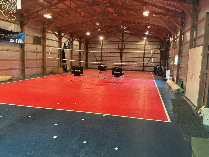 Conducted on-site evaluation for mini-split system installation in a 40' x 90' outbuilding converted to an indoor sports facility with no existing ductwork. Assessed the structure, which features exposed wooden beam construction with vaulted ceilings, multiple basketball courts, and volleyball playing areas with foam mat flooring. Documented facility layout and dimensions to determine optimal mini-split placement for heating and cooling the 3,600 square foot multipurpose athletic space, taking into account the high ceiling clearances, open floor plan, and recreational equipment positioning for proper air distribution throughout the building.