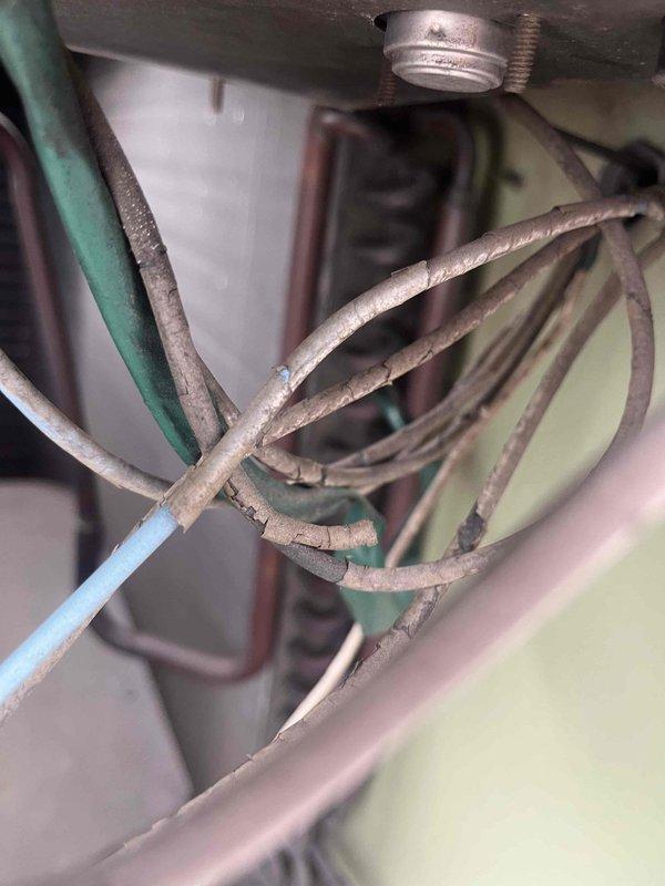 Responded to no cooling complaint on aging HVAC system. Upon inspection, discovered severely deteriorated wiring with cracked and flaking insulation exposing conductors, presenting both safety hazard and operational failure risk. Unit exterior showed extensive rust staining around ventilation openings and access panels, indicating prolonged moisture exposure and advanced age-related deterioration. Documented conditions with photographs and advised customer of necessary repairs before proceeding with any major work per dispatch instructions.