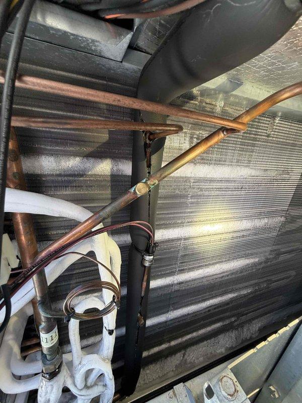 Responded to service call for commercial AC unit making clunking noise. Upon arrival, inspected ground-mounted unit and found system operational with no immediate cooling issues. Performed visual inspection of internal components including evaporator coil, refrigerant lines, and electrical connections. Coil showed normal dust accumulation for age of unit, copper lines exhibited typical oxidation, and all insulation appeared intact. Unit continued to operate normally during inspection with no unusual sounds detected at time of service.