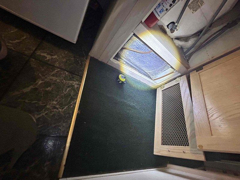 Conducted estimate for air conditioning installation in park model home. Assessed interior layout and existing infrastructure, including compact living space with skylight ventilation and wall-mounted access panels. Evaluated attic crawl space and existing ductwork system with reflective foil insulation to determine feasibility of AC integration with current HVAC configuration.