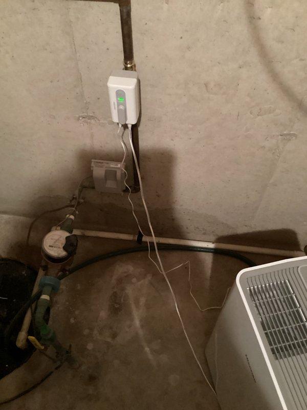 Installed motorized ball valve assembly with electric actuator in basement utility area. Mounted wall control unit with indicator light and completed electrical connections. Valve positioned to integrate with existing sump pump system for automated water flow control.