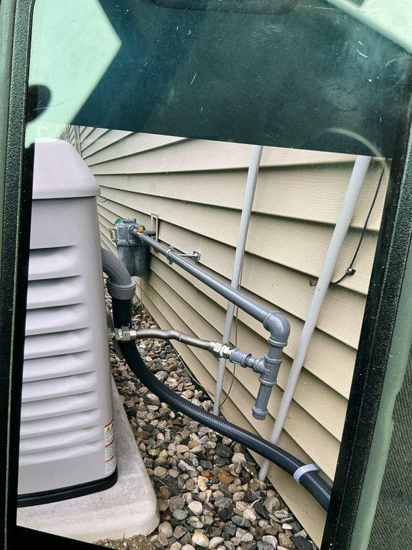 Successfully installed a 24kW Generac standby generator with 200-amp automatic transfer switch at residential property. Unit was positioned on concrete pad adjacent to home exterior with proper clearances maintained per manufacturer specifications and local code requirements. Gas supply lines were routed along exterior wall using appropriate mounting brackets and protective sleeving, ensuring secure installation and professional appearance. All electrical connections were completed between the generator, ATS, and main service panel. System was tested for proper operation including automatic transfer functionality and load management. Installation included proper grounding, weatherhead connections, and final startup procedures to verify seamless power transfer during utility outage simulation.