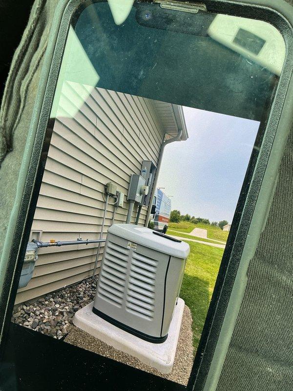 Successfully installed a 24kW Generac standby generator with 200-amp automatic transfer switch at residential property. Unit was positioned on concrete pad adjacent to home exterior with proper clearances maintained per manufacturer specifications and local code requirements. Gas supply lines were routed along exterior wall using appropriate mounting brackets and protective sleeving, ensuring secure installation and professional appearance. All electrical connections were completed between the generator, ATS, and main service panel. System was tested for proper operation including automatic transfer functionality and load management. Installation included proper grounding, weatherhead connections, and final startup procedures to verify seamless power transfer during utility outage simulation.