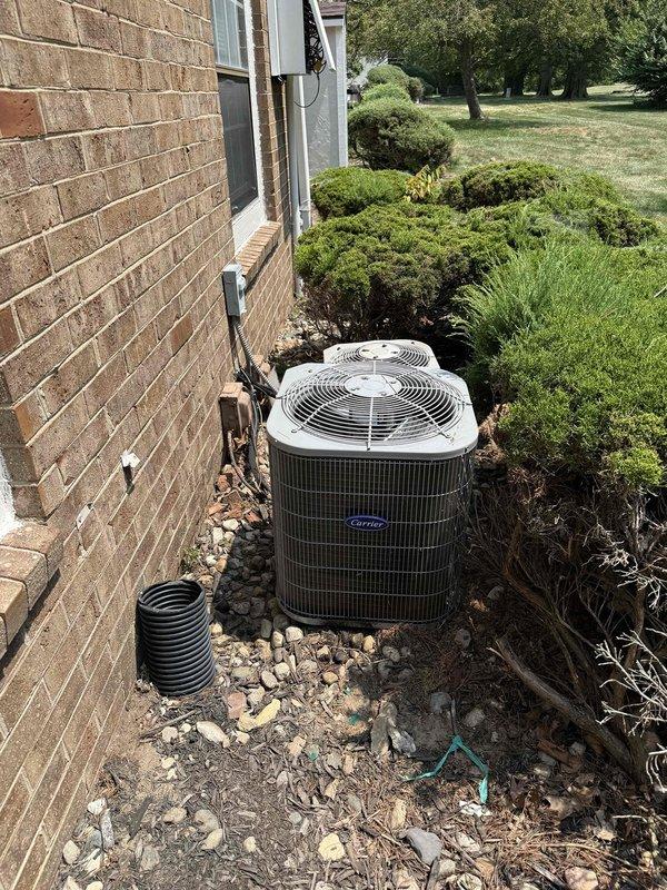 Completed full HVAC system replacement at end closet location. Installed new R454B refrigerant-compatible Carrier air conditioning condenser unit (model GA4SAN518) on exterior gravel pad with proper copper refrigerant line routing along brick exterior wall. Installed new air handler unit (model FMA5X2400AL) with integrated 8kW electric heat strip for supplemental heating. Verified all electrical connections, refrigerant lines, condensate drainage, and system controls for proper operation. Removed existing equipment and delivered to maintenance office for disposal per property requirements.