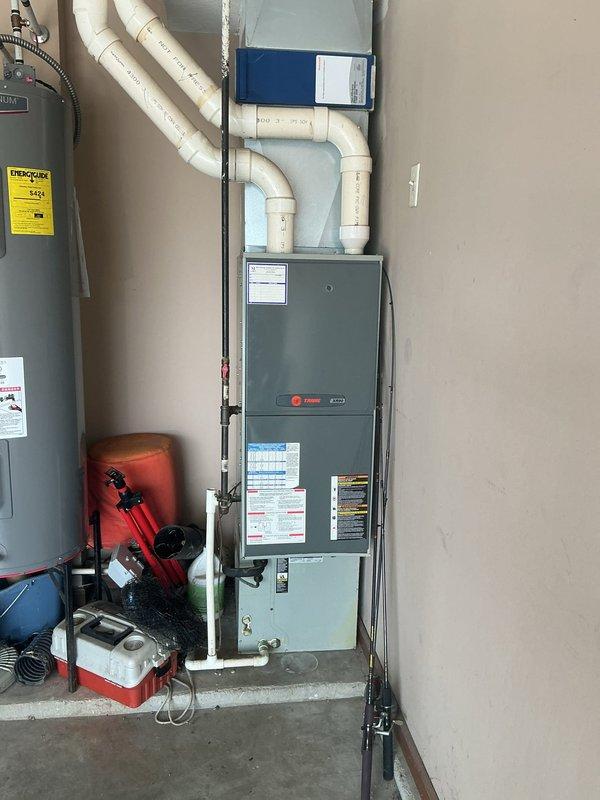 Responded to no cooling complaint and confirmed refrigerant leak at top of evaporator coil in R410A system. Documented existing Trane furnace with air handler installation and outdoor condensing unit positioned in side yard. Provided estimate for complete HVAC system replacement including new condenser, evaporator coil, and associated components due to coil leak requiring system upgrade.