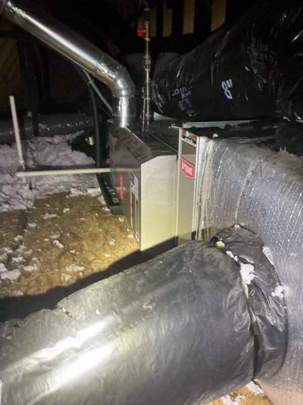 Completed comprehensive estimate for HVAC system replacement in a recently purchased two-story residence with basement. Assessed main floor furnace located in basement serving both basement and main floor areas, with existing AC unit in newer condition. Evaluated second floor system in attic space, accessing unit via pull-down stairs requiring 6-foot ladder. Documented attic-mounted furnace and air handler with existing ductwork and insulation conditions. Photographed outdoor condensing unit positioned on river rock base against exterior wall with proper electrical disconnect and condensate drainage. Noted potential undersizing concerns with second floor unit based on heating and cooling load requirements. Provided replacement options for basement furnace as standalone replacement, and complete furnace and AC system replacement for second floor attic installation to address capacity concerns and ensure proper comfort control for upper level.