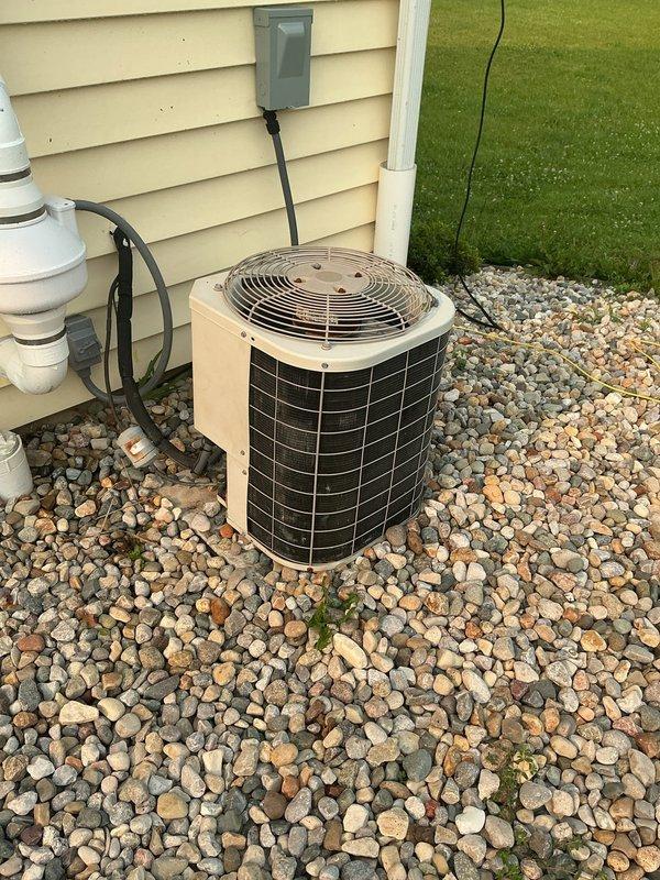 Completed comprehensive estimate for HVAC system replacement in a recently purchased two-story residence with basement. Assessed main floor furnace located in basement serving both basement and main floor areas, with existing AC unit in newer condition. Evaluated second floor system in attic space, accessing unit via pull-down stairs requiring 6-foot ladder. Documented attic-mounted furnace and air handler with existing ductwork and insulation conditions. Photographed outdoor condensing unit positioned on river rock base against exterior wall with proper electrical disconnect and condensate drainage. Noted potential undersizing concerns with second floor unit based on heating and cooling load requirements. Provided replacement options for basement furnace as standalone replacement, and complete furnace and AC system replacement for second floor attic installation to address capacity concerns and ensure proper comfort control for upper level.