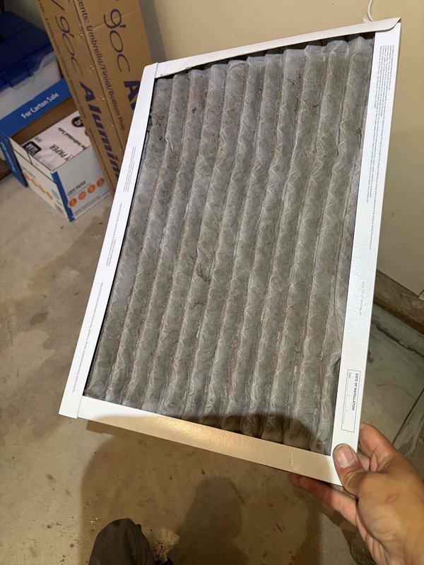 Responded to no cooling call on 10+ year old system. Upon arrival, found unit not blowing air. Inspected electrical components and capacitor mounted in ceiling assembly, noting age-related wear and accumulated dirt on wiring connections. Evaluated heavily soiled air filter with significant dust and debris accumulation restricting airflow. Addressed airflow issue and restored system operation.