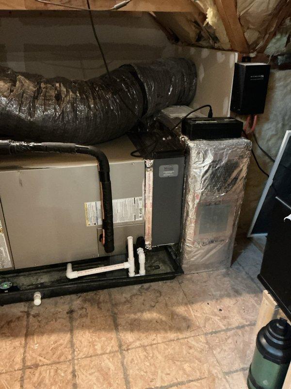 # Summary

Successfully completed geothermal HVAC system installation in attic space, including Carrier air handler unit with integrated iWave air purification system, properly configured ductwork, and condensate drainage system.

# Work Performed

Installed complete geothermal heating and cooling system in attic utility space. Positioned and secured Carrier brand air handler unit on OSB platform with appropriate structural support. Integrated iWave air purification technology into the air handler to enhance indoor air quality through ionization. Connected large-diameter flexible supply ductwork with proper insulation to minimize thermal loss and ensure efficient air distribution throughout the structure. 

Installed black refrigerant line set with appropriate insulation wrapping to prevent condensation and maintain system efficiency. Configured secondary equipment unit with reflective insulation barrier for temperature control and energy efficiency. Established proper condensate manag