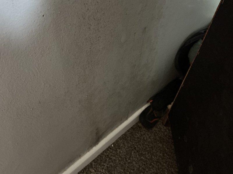 Responded to report of water spots appearing on interior walls during AC operation. Upon inspection, found visible water staining and discoloration on wall surface near baseboard area, with concentrated moisture damage pattern indicating active leak from HVAC system. Documented conditions with photos showing extent of wall deterioration and water intrusion points for further assessment and repair coordination.