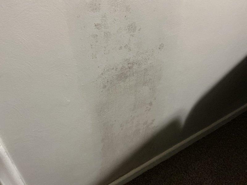 Responded to report of water spots appearing on interior walls during AC operation. Upon inspection, found visible water staining and discoloration on wall surface near baseboard area, with concentrated moisture damage pattern indicating active leak from HVAC system. Documented conditions with photos showing extent of wall deterioration and water intrusion points for further assessment and repair coordination.