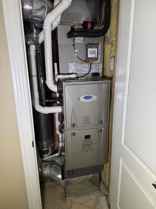 Completed full HVAC system replacement including installation of Carrier 59MN7C060C17-14 Infinity Series 98% AFUE modulating gas furnace with communicating capabilities, Carrier 26SPA624W003 Performance Series single-stage air conditioner, and Carrier CVAVA3017XMA evaporator coil. Removed and recycled existing equipment, reconnected to existing line set after flushing and pressure testing, and installed new 2" PVC condenser pad with pea gravel base. Upgraded from 80% efficiency system to 96%+ high-efficiency system requiring #2 installation kit for furnace changeout, installed white PVC condensate drainage system with proper routing and pitch, and mounted Honeywell Elite Pro S1200 thermostat with full programming and system explanation. Verified proper airflow, combustion analysis, and pressure switch operation using digital manometer showing differential pressures of 359 and 348 pascals, confirmed all electrical connections and safety controls operational, registered equipment warrant