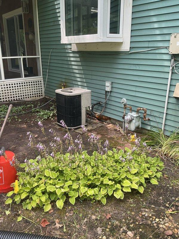 Conducted on-site evaluation of 28-year-old HVAC system and existing tanked water heater for complete replacement estimate. Assessed exterior condensing unit with cylindrical housing, refrigerant line routing, and interior mechanical space including floor drain and existing plumbing infrastructure. Provided comprehensive estimate for full system replacement including transition from tanked to tankless water heater configuration.