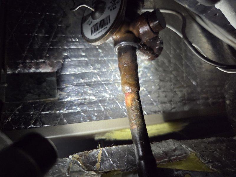 Responded to callback for no cooling condition with outdoor unit short cycling and water accumulation around furnace following recent TXV replacement. Upon inspection, discovered severe corrosion and rust on refrigerant piping connections, particularly on vertical pipe sections near copper fittings and T-joints within air handler cabinet. Corrosion exhibited active deterioration with heavy oxidation present on multiple copper line sections. Documented extensive pipe degradation and compromised connections that likely contributed to system malfunction and condensate issues. Photographed corroded refrigerant lines and deteriorated fittings for reference and potential warranty consideration related to previous repair work.