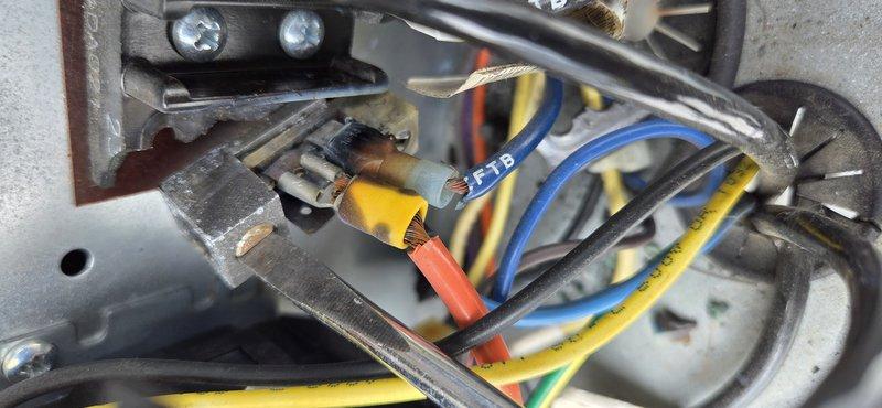 Replaced faulty terminal block with multiple wire connections showing signs of wear and aging. Secured all electrical connections including blue, yellow, red, orange, and black wires to new terminal assembly, ensuring proper wire routing and strain relief within the equipment enclosure. System tested and operational upon completion.