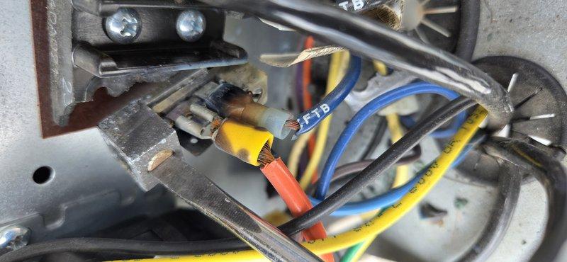 Replaced faulty terminal block with multiple wire connections showing signs of wear and aging. Secured all electrical connections including blue, yellow, red, orange, and black wires to new terminal assembly, ensuring proper wire routing and strain relief within the equipment enclosure. System tested and operational upon completion.