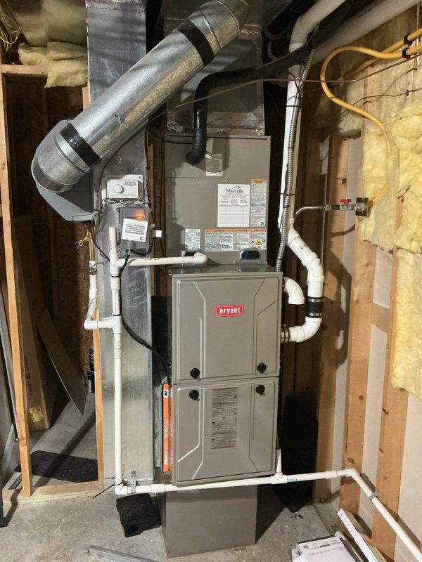 Completed installation of Carrier 26SPA636W003 air conditioning condenser unit and CVAVA4217XMA evaporator coil system. Positioned outdoor condenser on rubber pad with gravel base against building exterior, installed electrical disconnect box with proper conduit and wiring, and connected refrigerant lines between outdoor and indoor units. Indoor evaporator coil integrated with existing furnace system, with PVC condensate drainage piping installed and all ductwork connections properly sealed and secured.