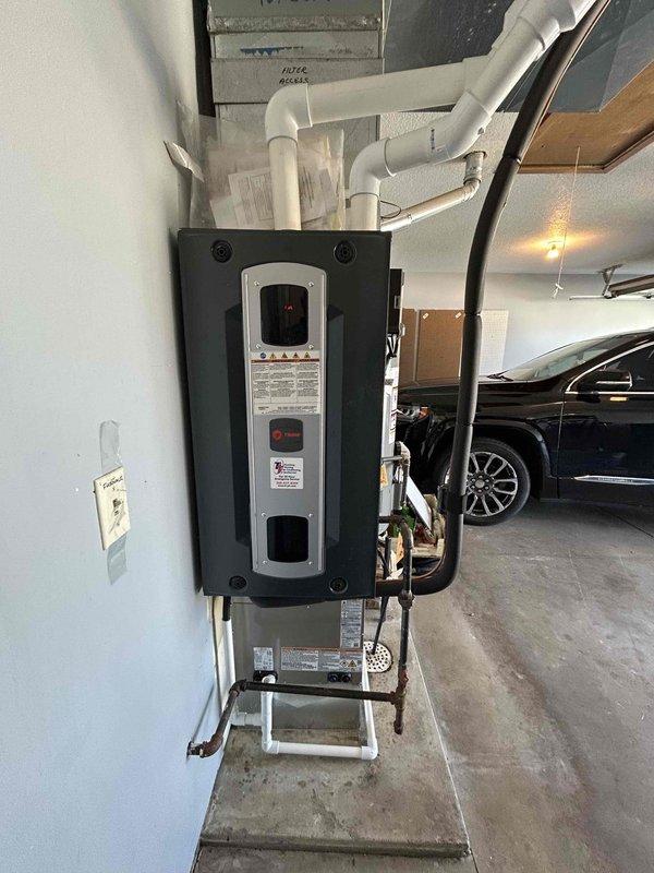 Conducted on-site evaluation for complete HVAC system replacement of 23-year-old existing equipment. Assessed current wall-mounted heating unit in garage and exterior air conditioning condenser unit. Documented existing system configuration including electrical connections, conduit routing, PVC condensate drainage, and equipment placement. Evaluated installation requirements for new equipment replacement including electrical service capacity, refrigerant line routing, and proper clearances for outdoor condenser unit positioned on gravel pad with landscape edging.
