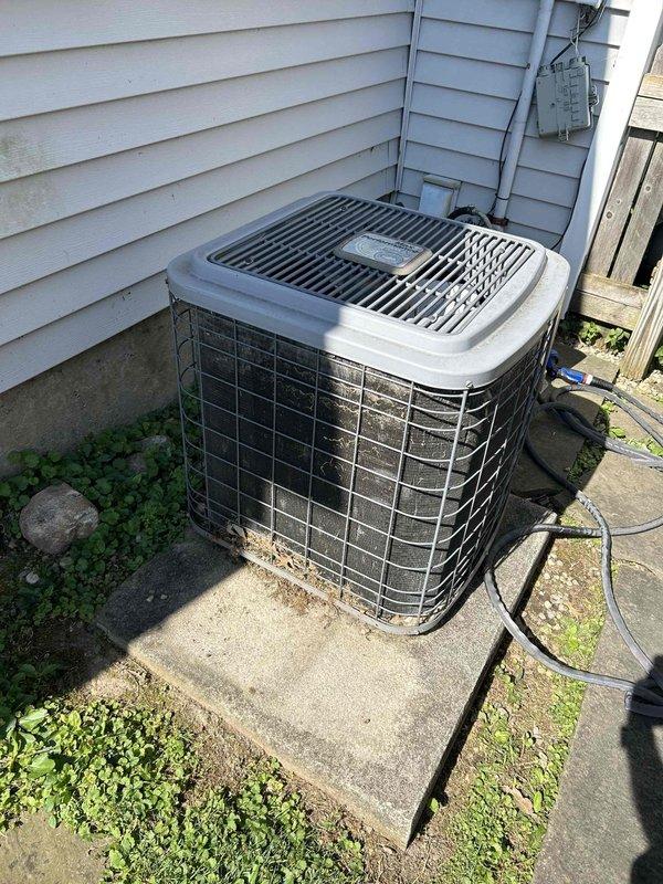 Responded to service call for frozen HVAC system at residential property. Upon arrival, assessed outdoor condenser unit positioned on concrete pad along side yard with gray vinyl siding. System evaluation revealed freezing condition requiring complete system replacement estimate. Provided comprehensive quote for new equipment installation while customer obtained competitive bids from multiple contractors. Documented existing tan/beige condenser unit configuration, electrical connections via wall-mounted meter box, and refrigerant line routing for replacement planning specifications.