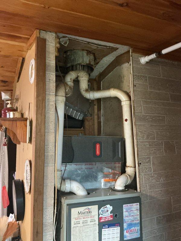 Completed estimate for air conditioner condenser replacement on an 11-year-old system experiencing compressor short cycling, ice buildup on refrigerant lines, and inadequate cooling. Previous technician diagnosed a faulty thermostatic expansion valve (TXV) as the primary issue. Documented existing Trane HVAC system configuration including furnace, air handler, and ductwork installation in basement utility area for replacement planning and equipment specifications.