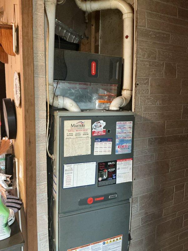 Completed estimate for air conditioner condenser replacement on an 11-year-old system experiencing compressor short cycling, ice buildup on refrigerant lines, and inadequate cooling. Previous technician diagnosed a faulty thermostatic expansion valve (TXV) as the primary issue. Documented existing Trane HVAC system configuration including furnace, air handler, and ductwork installation in basement utility area for replacement planning and equipment specifications.