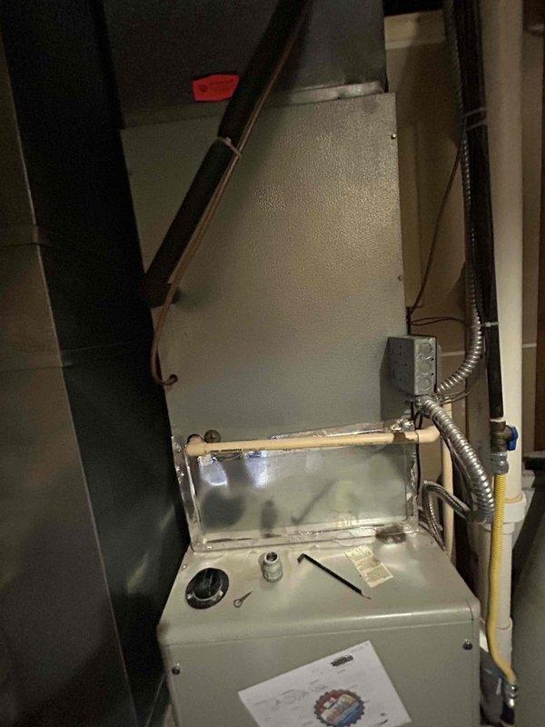 Completed on-site evaluation for HVAC system replacement at residential property. Documented existing furnace unit showing significant moisture accumulation and condensation on exterior surfaces, indicating potential heat exchanger failure or ventilation issues. Assessed water heater and gas line configuration in utility space, noting CSST gas connector routing and existing plumbing infrastructure. Provided comprehensive replacement estimate for new high-efficiency furnace system with proper venting and condensate management to address moisture concerns and improve system performance.
