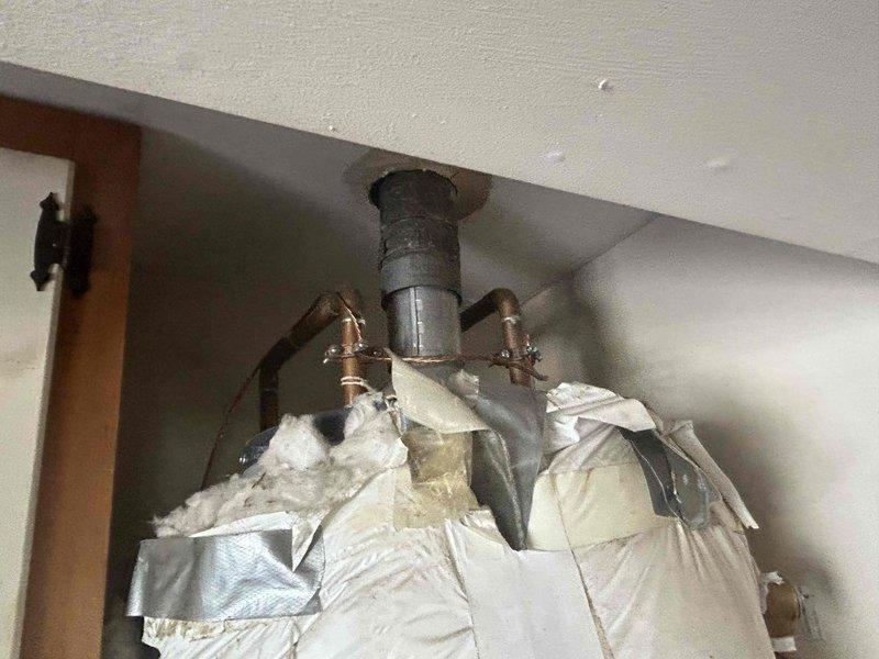 Conducted on-site assessment for tankless water heater conversion in residential garage. Evaluated existing tank-style water heater installation, documenting current plumbing configuration including copper supply lines, gas connections, and venting requirements. Measured clearances and photographed existing piping penetrations through ceiling structure to determine necessary modifications for tankless unit installation and provided comprehensive quote for replacement.