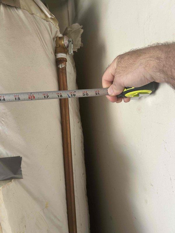 Conducted on-site assessment for tankless water heater conversion in residential garage. Evaluated existing tank-style water heater installation, documenting current plumbing configuration including copper supply lines, gas connections, and venting requirements. Measured clearances and photographed existing piping penetrations through ceiling structure to determine necessary modifications for tankless unit installation and provided comprehensive quote for replacement.