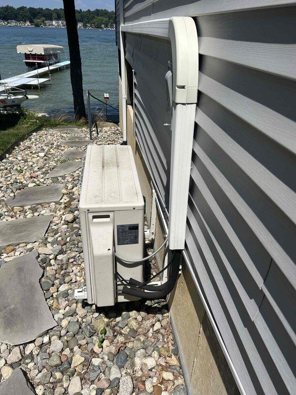 Conducted estimate for mini-split system replacement in three-season room. Evaluated existing Fujitsu 12,000 BTU 1-to-1 ductless heat pump system experiencing refrigerant leak rendering unit inoperative. Documented current installation including outdoor condenser unit mounted on concrete pad and wall-mounted indoor air handler with refrigerant line set and electrical connections. Assessed installation site conditions on lakeside property with adequate clearances and proper drainage. Provided replacement options for failed system while noting main residence has separate central heating and cooling equipment.
