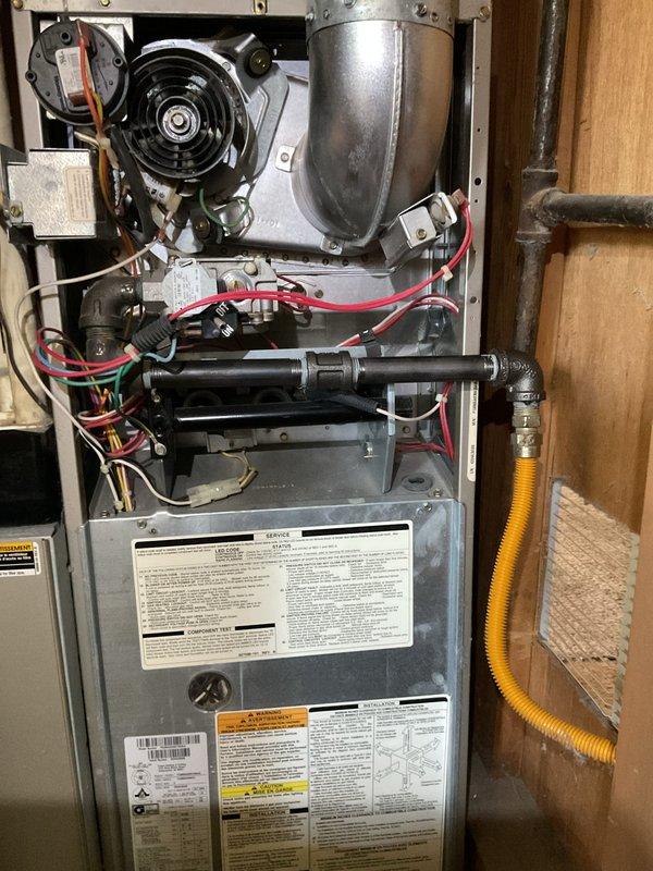 Installed black iron gas pipe to exterior of furnace cabinet and connected to existing gas line per code requirements. Replaced corroded and leaking copper water line at water meter with new supply piping. Extended TPR valve discharge piping to terminate within 6 inches of floor level to meet safety standards.