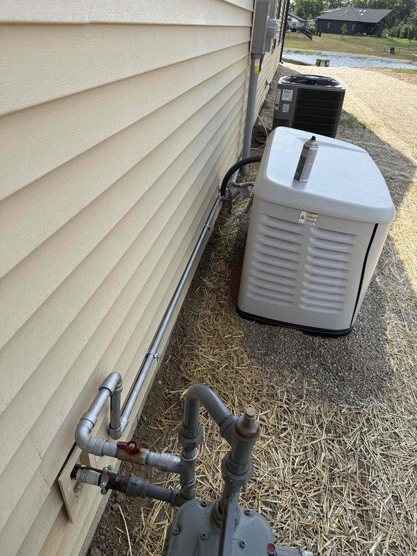Installed natural gas line from existing residential gas meter to backup generator location. Ran approximately 8-10 feet of black iron pipe with appropriate fittings, elbows, and shut-off valve to supply fuel source for standby generator unit. Connected piping to meter assembly using code-compliant materials and secured all connections. Installation positioned along exterior foundation wall near existing HVAC equipment pad to maintain clean routing and accessibility for future service needs.