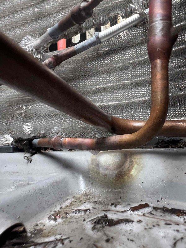 # HVAC Repair Summary

Responded to refrigerant leak in residential air conditioning system. Upon inspection, identified compromised refrigerant line connections with visible frost accumulation on evaporator coil assembly and moisture present in drain pan. Performed minor refrigerant repair at leak point on copper line connections. Conducted pressure test using nitrogen to verify system integrity and confirm leak repair was successful. Evacuated system to remove moisture and contaminants. System tested and returned to normal operation with proper refrigerant flow and no further leak detected.