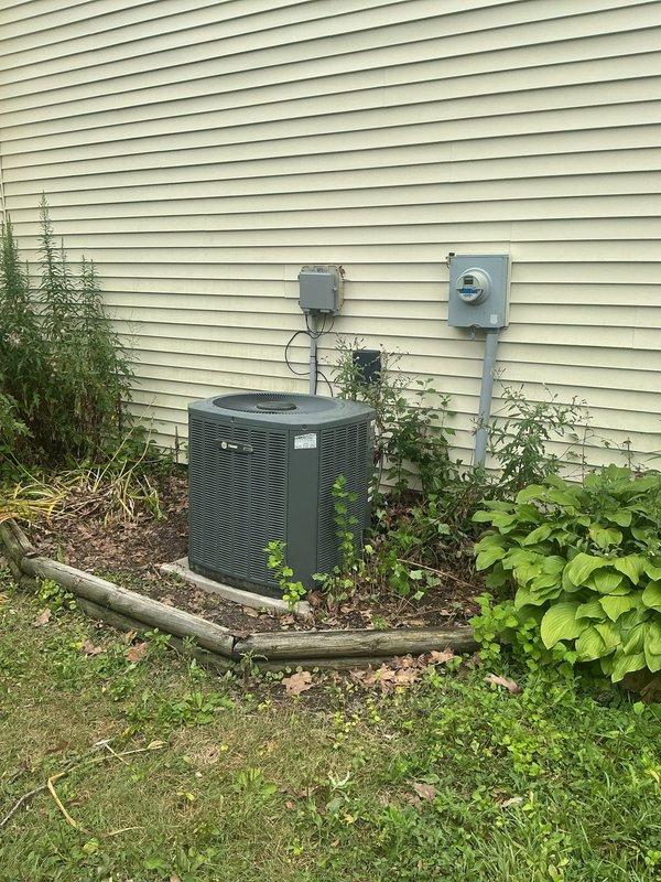 Completed comprehensive HVAC system replacement estimate for residential property. Assessed existing outdoor condensing unit positioned in landscaped area with adequate clearance concerns due to surrounding vegetation, and evaluated indoor furnace system located in basement utility room showing signs of age and wear. Documented current equipment specifications, electrical connections including disconnect box and meter configuration, refrigerant line routing, condensate drainage system, and ductwork connections to provide accurate replacement recommendations for complete system upgrade.